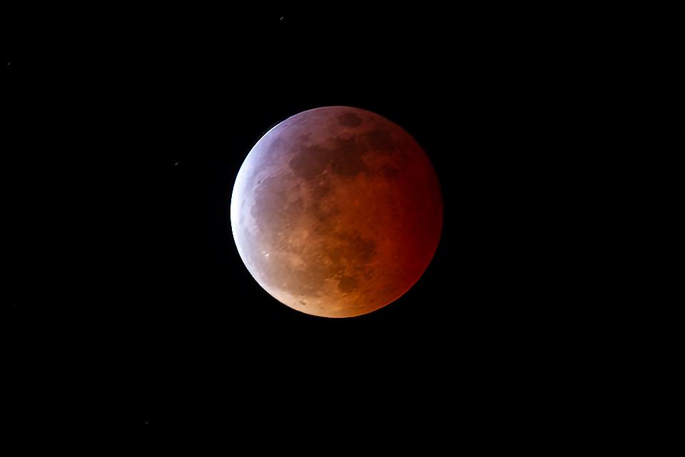 a lunar eclipse, where the moon turns red and looks shadowed
